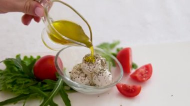 Mozzarella üzerine zeytinyağı serpiştir. Caprese salatasının üzerine zeytinyağı dökmek. Yoğurt peyniri ve provenkal otlar.