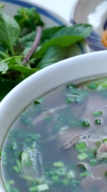 Geleneksel Vietnam pho çorbası sığır eti dilimleri, erişte ve bir kasede taze otlar, Vietnam mutfağı konsepti. Yüksek kalite 4k görüntü