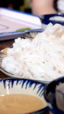 pirinç vermicelli noodle erkek garson Asya restoranında yemek servisi yapıyor. Yüksek kalite 4k görüntü