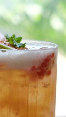 Guava ve portakallı yaz kokteylleri pencerenin yanındaki masada kurutulmuş meyve ve naneli pipetli buzlu içecekler var. Yüksek kalite 4k görüntü