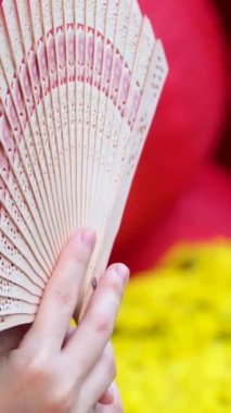 Kırmızı arka planda, elinde ayçiçekleri olan tanınmayan Asyalı bir kız var. Yüksek kalite 4k görüntü