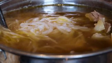 pirinç erişte çorbası. Çorbayı Vietnam çubuklarıyla karıştır.