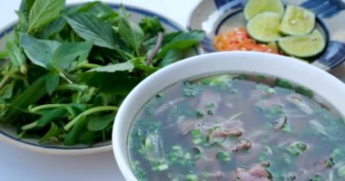Geleneksel Vietnam pho çorbası sığır eti dilimleri, erişte ve bir kasede taze otlar, Vietnam mutfağı konsepti. Yüksek kalite 4k görüntü