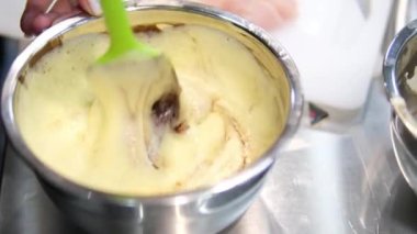 Çikolatalı pasta yapma sürecinde adım adım. Kadın eli yumurta ve tereyağını karıştırıcı ile karıştırır. Çikolatalı browni hazırlama işlemleri masanın üzerinde. yatay. 