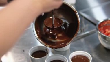 Çikolata şekeri pişirmek, kalıplara dökmek, kalıplara dökme işlemi. Yüksek kalite 4k görüntü