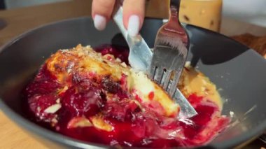 Bıçakla kesilmiş, çatallı, süzme peynirli krep ve vişne reçeli. Yüksek kalite 4k görüntü