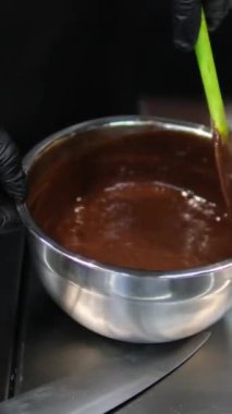 Çikolatalı pasta yapma sürecinde adım adım. Kadın eli yumurta ve tereyağını karıştırıcı ile karıştırır. Çikolatalı browni hazırlama işlemleri masanın üzerinde. yatay. 