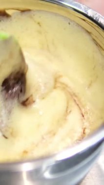 Çikolatalı pasta yapma sürecinde adım adım. Kadın eli yumurta ve tereyağını karıştırıcı ile karıştırır. Çikolatalı browni hazırlama işlemleri masanın üzerinde. yatay. 