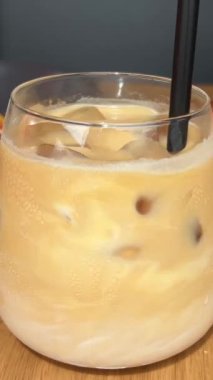 Güzel tasarlanmış bir sütlü kahvenin ve taze pişmiş kruvasanın beyaz tabakta üst görüntüsü. Kahvaltıyı, kahve molalarını ve yemek anlarını canlandırmak için mükemmel bir görüntü. Yüksek kalite