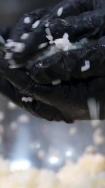 Suşi için pilav pilavı pilav yap. Siyah eldivenli eller suşi hazırlıyor.