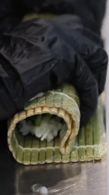 Şef, Nuri yosununa pirinç koyarak suşi hazırlıyor. Yüksek kaliteli suşi paspası.