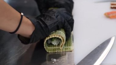 Şef, Nuri yosununa pirinç koyarak suşi hazırlıyor. Yüksek kaliteli suşi paspası.