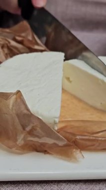 Yunan salatası için panoya peynir dilimleme ya da dilimleme. Sağlıklı yiyecekler. Yüksek kalite 4k görüntü