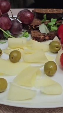 Üzüm, domates, yeşil zeytin, siyah ekmek, Provencal otlar, peynirli dilimler lüks otel kahvaltısı veren lezzetli bir restoranda. 4k