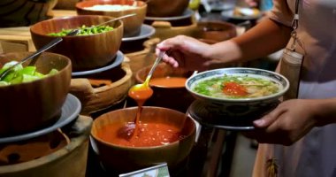 Büyük bir yemek kaşığıyla ketçap kepçesinde kaşıkla açık büfe sosu. Bir kaşıkla domates sosu.