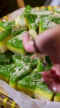 Hasır sepette, yeşil ve sarı tatlı susam tohumları serpiştirilmiş Warabimochi eğreltiotu nişastasından yapılmış ve kinako soya unu ve şekerle kaplanmış jöle benzeri bir tatlıdır..