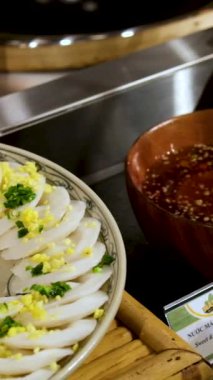 Açık büfedeki adam farklı sosları balık yumurtasının üzerine döküyor. Mavi tabakta kaynamış yumurta yarıları, yakın görüş. Paskalya, sağlıklı bir atıştırmalık.