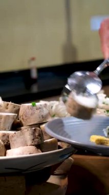 Açık büfedeki adam tatlı patates yuca kökü seçiyor. Mor tatlı yer elması Tahta kasede dilimlenmiş 