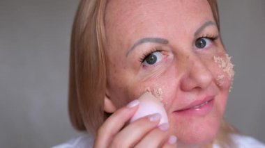 Güzellik mikserinin yüzüne kadın eli ile vurmak için temeli uygula. Cilde temel tonu karıştırmak veya uygulamak için sünger kullanan bir kadın. Makyaj için profesyonel araçlar, kozmetik ürünleri konsepti.