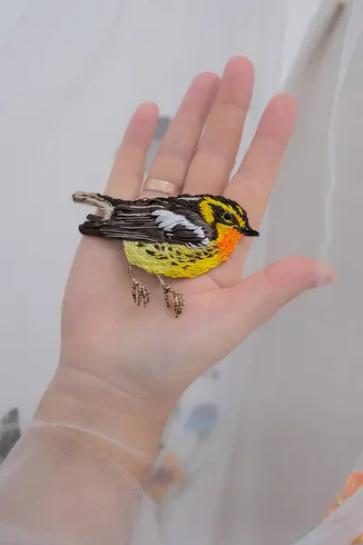 Çiçek nakışları ve duvağa takılmış kuşlar ince bir kumaş üzerinde bir kadın, parlak süslemeli bir manken gelinliğine el işi düzleştiriyor. Yüksek kalite 4k