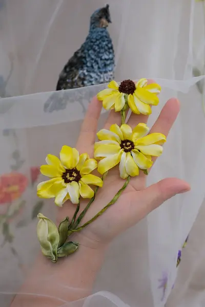 Çiçek nakışları ve duvağa takılmış kuşlar ince bir kumaş üzerinde bir kadın, parlak süslemeli bir manken gelinliğine el işi düzleştiriyor. Yüksek kalite 4k
