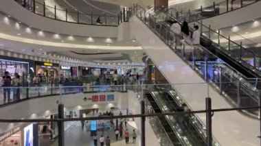 Ünlü markalardan oluşan farklı butiklere sahip büyük mağazalar merdivenlerden çıkıp beyaz cam bina içinde yürüyen merdivenlere çıkıyorlar. Birçok alıcı Vietnam Ho Chi Minh Şehri 10.12.2024 'te satın alıyor.