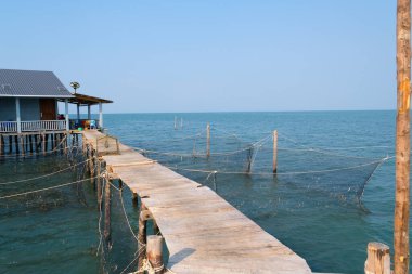 fishing village indian ocean on phu quoc island beautiful water surface fish fish farming wooden bridge house against the backdrop of extraordinary wild nature. High quality 4k footage clipart