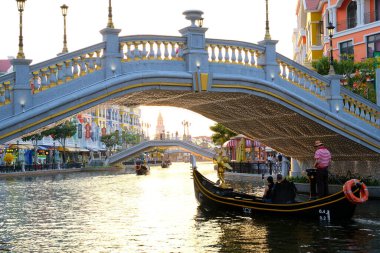 Büyük dünya, Vietnam, son eğlence. Kadın ve erkek gondol kayıkçısı kırmızı çizgili süveter ve şapka şamandıra ile arkadan motorlu tekne Phu Quoc 06.16.2024 'e ateş ediyorlar.