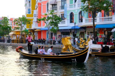 Büyük dünya, Vietnam, son eğlence. Kadın ve erkek gondol kayıkçısı kırmızı çizgili süveter ve şapka şamandıra ile arkadan motorlu tekne Phu Quoc 06.16.2024 'e ateş ediyorlar.