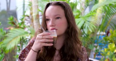 Güzel, neşeli Avrupalı bir kız yoğun sütlü kahve içiyor ve Vietnam 'a kaşıkla seyahat ediyor. İyi eğlenceler. Yüksek kaliteli FullHD görüntüler