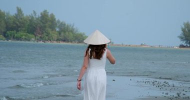 Vietnam vatandaşı şapkalı Avrupalı sarışın kız çeltik havuzunun yanında poz veriyor ve fotoğrafçı kız fotoğraf çekiyor. Yüksek kaliteli FullHD görüntüler