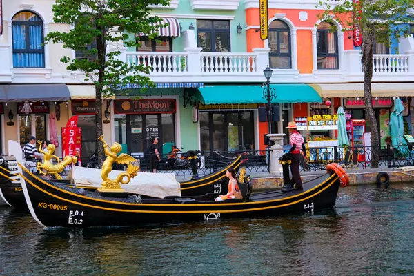 Büyük kanal nehri boyunca uzanan ünlü binalar ve oradan geçen bir gondol. Gondol Vietnam Phu Quoc Adası 06.15.2024