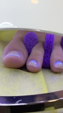 Ultraviyole lambanın altındaki tırnaklara jel cilası yapıştırmak. Shellac kaplamalı manikür. Ultraviyole lambayla kurutma işlemi. Jöle cilası lambası için