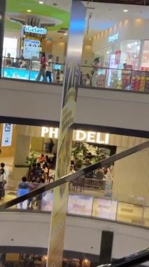 Ünlü markalardan oluşan farklı butiklere sahip büyük mağazalar merdivenlerden çıkıp beyaz cam bina içinde yürüyen merdivenlere çıkıyorlar. Birçok alıcı Vietnam Ho Chi Minh Şehri 10.12.2024 'te satın alıyor.