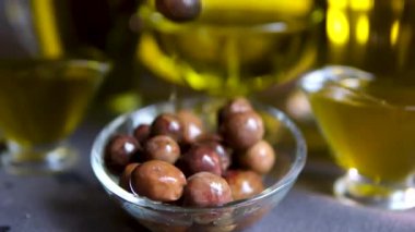 Süper yavaş çekimde taze olgun zeytin makrosu biyo-organik altın sıvı ekstra saf zeytinyağına dökülüyor ve olgun zeytinlere damlıyor. Yüksek kalite 4k görüntü