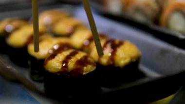 Suşi seti, somon balığı, ton balığı, yılan balığı, karides, susam, yakın plan, suşi Japon yemeği, deniz ürünleri, reklam suşi ruloları, üst görüş. Yüksek kalite 4k görüntü