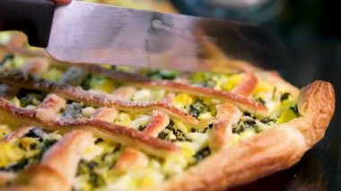 Ispanaklı klasik Quiche. Balık turtası. Mutfak masasında açık yüzlü somon kiş brokoli parçaları ve arka planda lezzetli turta. 4k görüntü