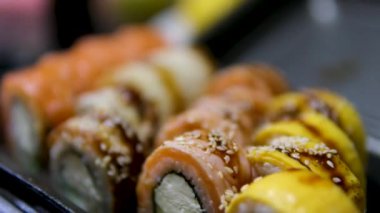 Suşi seti, somon balığı, ton balığı, yılan balığı, karides, susam, yakın plan, suşi Japon yemeği, deniz ürünleri, reklam suşi ruloları, üst görüş. Yüksek kalite 4k görüntü