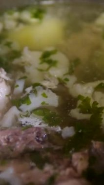 Sebze çorbası, et aşçısı, bir tencere içinde kaşık karnabahar ve domuz tavuğu ile karıştırılmış. Yüksek kalite 4k görüntü