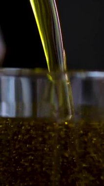 Farklı tabaklara yakın çekim zeytinyağı dökülüyor. Yemek pişirmek için mi yoksa salata sosu olarak mı kullanılıyor? Zeytinyağı yemek ve salatalar için popüler bir ek maddedir. - Evet. Yüksek kalite 4k görüntü