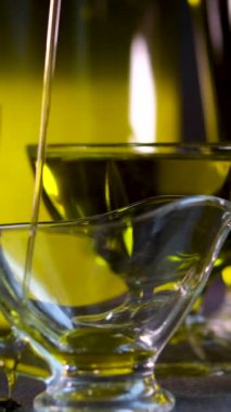 Zeytin ya da ayçiçeği yağı, sebze, cam bir şişenin boynundan dökülüyor. Yakın plan. Yüksek kalite 4k görüntü