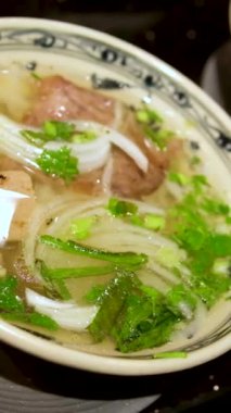 Geleneksel Vietnam pho çorbası sığır eti dilimleri, erişte ve bir kasede taze otlar, Vietnam mutfağı konsepti. Vietnam Pho Çorbası