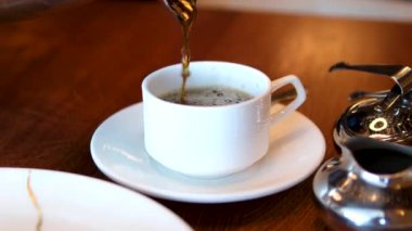 Çay fincanına çay koyun. Bitki ve böğürtlenli çay şeffaf bir çay bardağına dökülür..