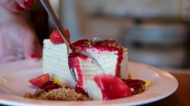 İnce kremalı ince pastalı ince pastalar. Kahvaltıda krema sürülmüş beyaz bir tabaktan alınmış ince bir kaşıkla birçok kat çilek reçeli yemek. Yüksek kalite 4k görüntü