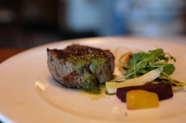 Lezzetli, sulu biftek ızgarada kızarır. Fileminyon bifteği ızgarada pişiyor. Et, biftek, biberiye filizi, sıcak yağ. Makro. Filet Mignon