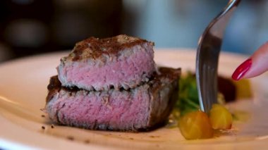 Lezzetli, sulu biftek ızgarada kızarır. Fileminyon bifteği ızgarada pişiyor. Et, biftek, biberiye filizi, sıcak yağ. Makro. Filet Mignon