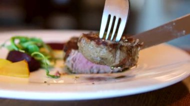 Lezzetli, sulu biftek ızgarada kızarır. Fileminyon bifteği ızgarada pişiyor. Et, biftek, biberiye filizi, sıcak yağ. Makro. Filet Mignon