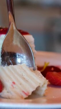 Beyaz pasta, ince pastalar, üzerinde çilek reçeli olan katmanlar kahvaltıda krema sürülmüş beyaz tabaktan ince bir kaşıkla yemek. Yüksek kalite 4k görüntü