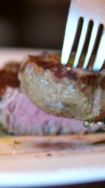 Lezzetli, sulu biftek ızgarada kızarır. Fileminyon bifteği ızgarada pişiyor. Et, biftek, biberiye filizi, sıcak yağ. Makro. Filet Mignon