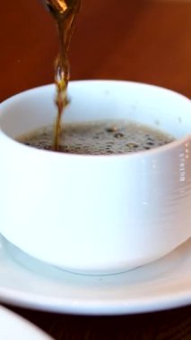 Çay fincanına çay koyun. Bitki ve böğürtlenli çay şeffaf bir çay bardağına dökülür..